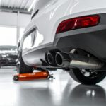 A car being sold while a THOR TUNING electronic exhaust unit is being removed and transferred to another vehicle. Clean, modern, automotive magazine style.