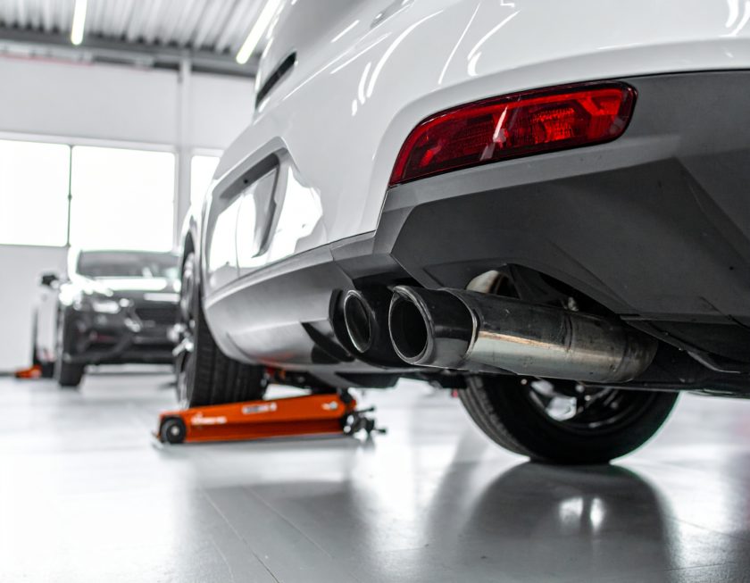 A car being sold while a THOR TUNING electronic exhaust unit is being removed and transferred to another vehicle. Clean, modern, automotive magazine style.